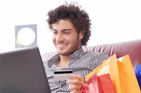 a young man  using his credit card to purchase over the internet, happiness and amazement Stock Photo - Budget Royalty-Free & Subscription, Code: 400-04783896