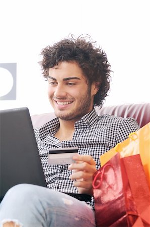 a young man  using his credit card to purchase over the internet, happiness and amazement Stock Photo - Budget Royalty-Free & Subscription, Code: 400-04783897