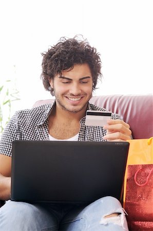 a young man  using his credit card to purchase over the internet, happiness and amazement Stock Photo - Budget Royalty-Free & Subscription, Code: 400-04783891