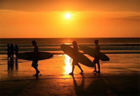 passtime - Silhouettes of three surfers at red sunset. Kuta beach, Bali, Indonesia Stock Photo - Budget Royalty-Free & Subscription, Code: 400-04795230