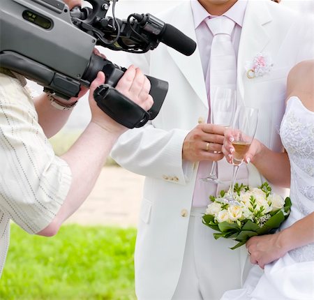 Operator films a happy newly-married couple, holding glasses of champagne Stock Photo - Budget Royalty-Free & Subscription, Code: 400-04798910