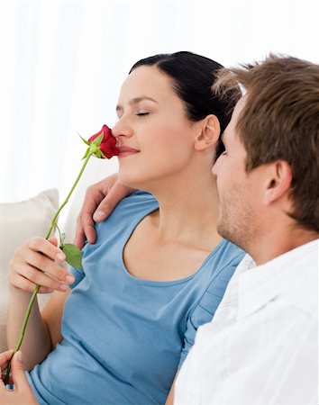 simsearch:400-07726699,k - Lovely wwoman smelling a rose sitting on the sofa with her boyfriend Foto de stock - Super Valor sin royalties y Suscripción, Código: 400-04791718