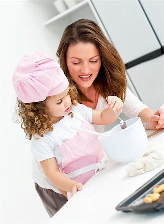 simsearch:400-05749768,k - Little girl with her beautiful mother cooking together in the kitchen Stock Photo - Budget Royalty-Free & Subscription, Code: 400-04791775