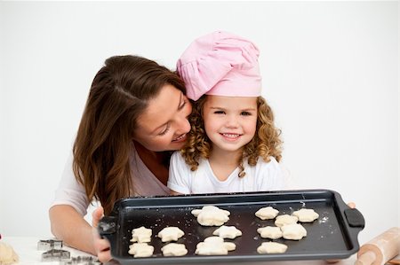 simsearch:400-05749768,k - Happy little girl with her mother showing a plate with biscuits to the camera Stock Photo - Budget Royalty-Free & Subscription, Code: 400-04791785