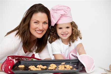 rolling over - Lovely mother and daughter holding a plate with biscuits in the kitchen Foto de stock - Super Valor sin royalties y Suscripción, Código: 400-04791786