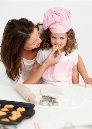 simsearch:400-05749768,k - Little girl tasting a biscuit with her mother in the kitchen Stock Photo - Budget Royalty-Free & Subscription, Code: 400-04791781