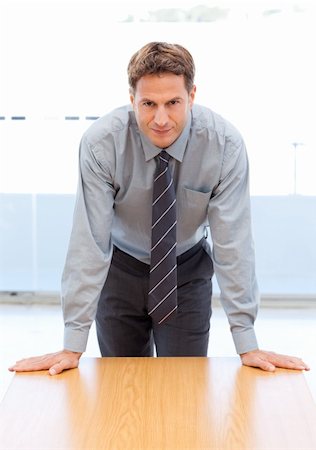 simsearch:400-05742796,k - Confident businessman posing leaning on a table in an office Stock Photo - Budget Royalty-Free & Subscription, Code: 400-04791950