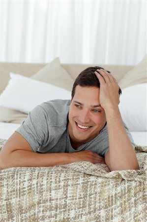 Happy man smiling lying on his bed at home Stock Photo - Budget Royalty-Free & Subscription, Code: 400-04791979