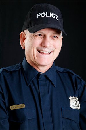 first responder - Portrait of a friendly, laughing policeman.  Studio shot against black background. Stock Photo - Budget Royalty-Free & Subscription, Code: 400-04792205