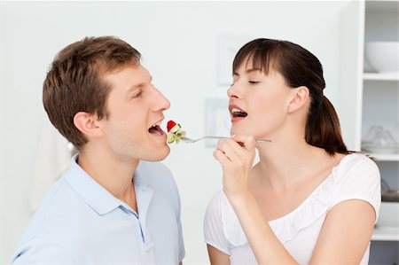 simsearch:400-04853599,k - Happy couple eating together in the kitchen Foto de stock - Royalty-Free Super Valor e Assinatura, Número: 400-04804381