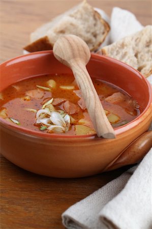 stew sausage - Goulash soup with meat sausage and potatoes garnished with spring onion in a brown bowl. Shallow dof Stock Photo - Budget Royalty-Free & Subscription, Code: 400-04805298