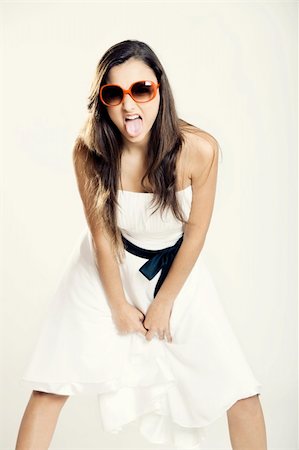 Beautiful young woman with a white dress and sunglasses showing her tongue out Stock Photo - Budget Royalty-Free & Subscription, Code: 400-04806531