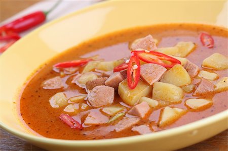 stew sausage - Wurst goulash soup with meat sausage and potatoes garnished with red chili on yellow plate. Shallow dof Stock Photo - Budget Royalty-Free & Subscription, Code: 400-04807562