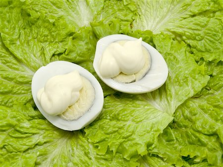 Two boiled eggs are watered from above by mayonnaise and are on leaves of green salad Stockbilder - Microstock & Abonnement, Bildnummer: 400-04807652