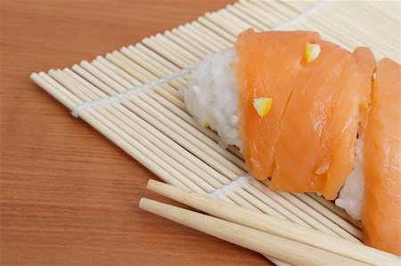 simsearch:400-08192842,k - Closup photo of salmon sushi and chopsticks on bamboo mat Foto de stock - Super Valor sin royalties y Suscripción, Código: 400-04808152