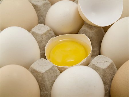 One broken egg is in one tray with the whole eggs Stockbilder - Microstock & Abonnement, Bildnummer: 400-04808867