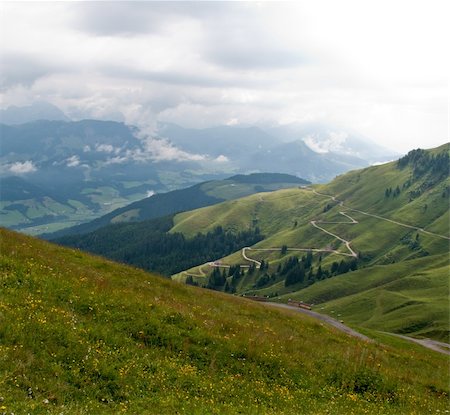 Hairpin bends on road up the grassy slopes on cloudy day in Switzerland Stockbilder - Microstock & Abonnement, Bildnummer: 400-04808916