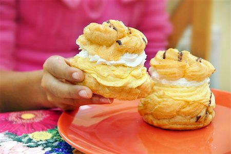 simsearch:400-05347658,k - two sweet cakes filled with yellow and white cream in girl hands Photographie de stock - Aubaine LD & Abonnement, Code: 400-04808988