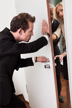 Businessman pushing the door to prevent people entering room Stock Photo - Budget Royalty-Free & Subscription, Code: 400-04809805