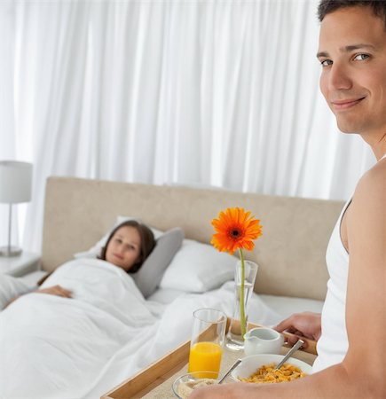 Portrait of a man bringing the breakfast to his girlfriend in the bedroom Stock Photo - Budget Royalty-Free & Subscription, Code: 400-04800482