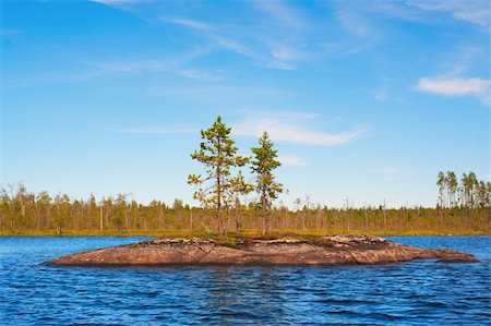 simsearch:400-04750401,k - Island in the form of a smooth rock with several pines on stones on blue lake Foto de stock - Royalty-Free Super Valor e Assinatura, Número: 400-04800760