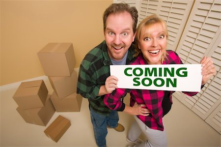 Goofy Couple Holding Coming Soon Sign in Room with Packed Cardboard Boxes. Stock Photo - Budget Royalty-Free & Subscription, Code: 400-04801470