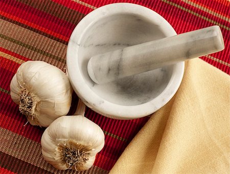 Overhead shot of two garlic bulbs beside a marble mortar and pestle and linen napkin. Background is striped red and yellow cloth Photographie de stock - Aubaine LD & Abonnement, Code: 400-04803316