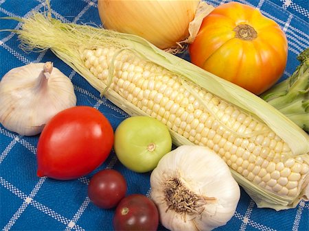 Overhead shot of raw vegetables - corn, tomatoes, garlic on blue checkered cloth Photographie de stock - Aubaine LD & Abonnement, Code: 400-04803359