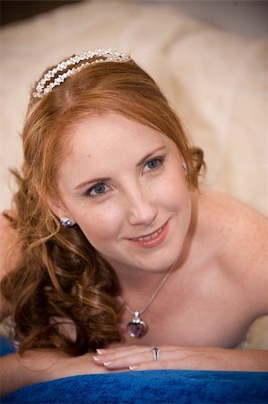 simsearch:400-04161971,k - red head sexy beautiful bride laying down on her elbows with cleavage visible and leaning on her hands whilst smiling Stock Photo - Budget Royalty-Free & Subscription, Code: 400-04803388