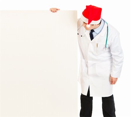 simsearch:400-05745246,k - Medical doctor in Santa hat looking at blank billboard isolated on white Photographie de stock - Aubaine LD & Abonnement, Code: 400-04803453