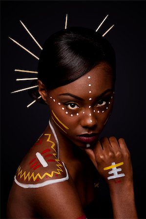 Beautiful exotic African female fashion face with tribal yellow red and white makeup cosmetics and sticks in hair. Stock Photo - Budget Royalty-Free & Subscription, Code: 400-04803758