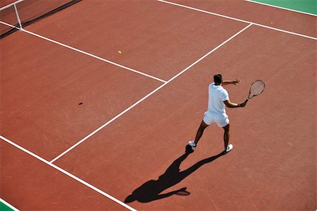 simsearch:400-06061549,k - young man play tennis outdoor on orange tennis field at early morning Photographie de stock - Aubaine LD & Abonnement, Code: 400-04815866