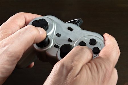 franky242 (artist) - hands holding silver gamepad of video game Fotografie stock - Microstock e Abbonamento, Codice: 400-04817462