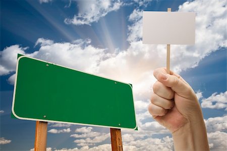 simsearch:400-04628504,k - Blank Green Road Sign and Man Holding Poster on Stick Over Blue Sky and Clouds. Foto de stock - Royalty-Free Super Valor e Assinatura, Número: 400-04817802