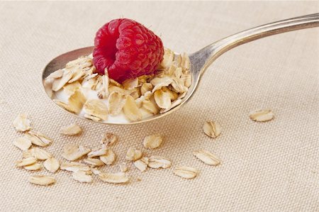 spoon of oatmeal cereal with a fresh raspberry and milk over tablecloth Stock Photo - Budget Royalty-Free & Subscription, Code: 400-04819157