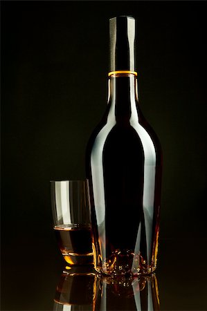 simsearch:6102-03828319,k - A bottle and a glass of cognac in a black background Stock Photo - Budget Royalty-Free & Subscription, Code: 400-04811102