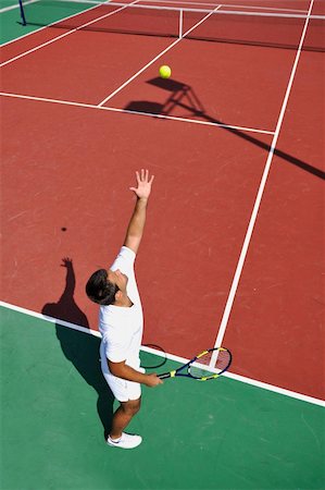 simsearch:400-06061549,k - young man play tennis outdoor on orange tennis court at early morning Photographie de stock - Aubaine LD & Abonnement, Code: 400-04811331