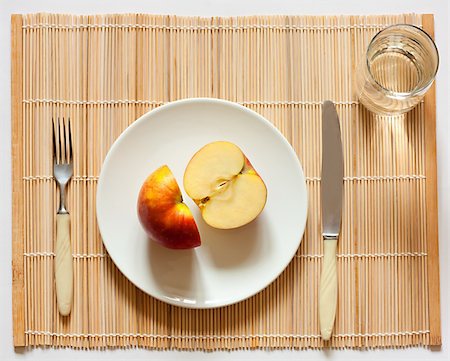 Apple on a plate. There is a knife, a fork and a water glass. Fotografie stock - Microstock e Abbonamento, Codice: 400-04812200