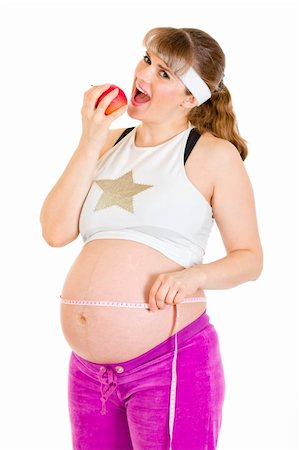 Smiling beautiful pregnant woman holding measure tape and  eating apple isolated on white Stock Photo - Budget Royalty-Free & Subscription, Code: 400-04812927