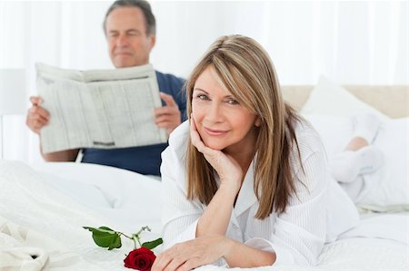 simsearch:400-07726699,k - Happy woman with her rose while her husband is reading a newspaper at home Foto de stock - Super Valor sin royalties y Suscripción, Código: 400-04813097
