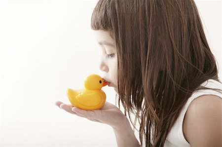 little toddler girl kissing a yellow bath duck on white background Stock Photo - Budget Royalty-Free & Subscription, Code: 400-04820093