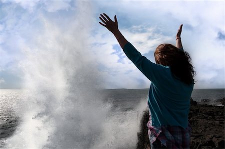 a lone woman raising her arms in awe at the powerful waves on the cliffs edge in county clare ireland Foto de stock - Royalty-Free Super Valor e Assinatura, Número: 400-04820285