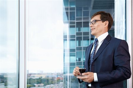 Business man with a cup of coffee in the office Stock Photo - Budget Royalty-Free & Subscription, Code: 400-04822095