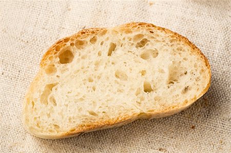 Slice of a homemade bread on a linen tablecloth. Photographie de stock - Aubaine LD & Abonnement, Code: 400-04822879