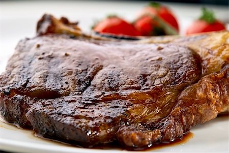 Macro of grilled meat ribs on white plate with tomatoes chives and dark hot sauce Fotografie stock - Microstock e Abbonamento, Codice: 400-04823763