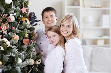 The smiling family of three people close to the spruce Stock Photo - Budget Royalty-Free & Subscription, Code: 400-04823950