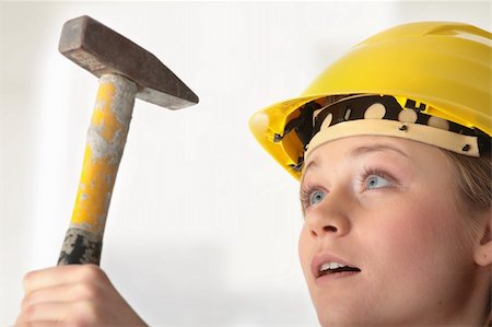 Beautiful girl in yellow helmet holding hummer. Stockbilder - Microstock & Abonnement, Bildnummer: 400-04836224