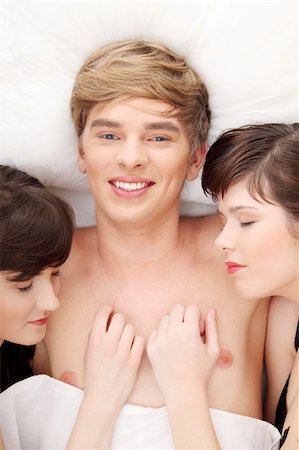 Young handsome man lying in bed with two girls Photographie de stock - Aubaine LD & Abonnement, Code: 400-04836302