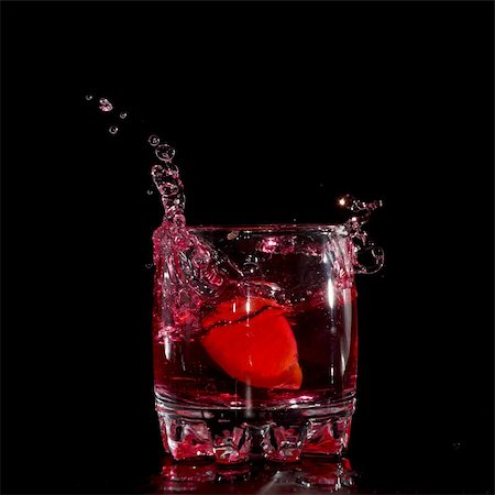 fresh glass of ice water - red martini cocktail splashing into glass on black background Stock Photo - Budget Royalty-Free & Subscription, Code: 400-04836976