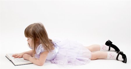 Young girl in pink dress lying and reading a book Fotografie stock - Microstock e Abbonamento, Codice: 400-04837762